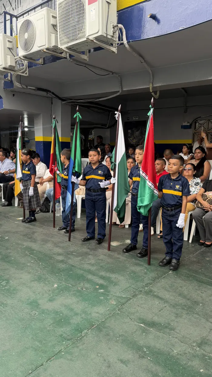 Estudiantes del colegio Juan XXIII con las banderas en el patio durante el Día de la Bandera