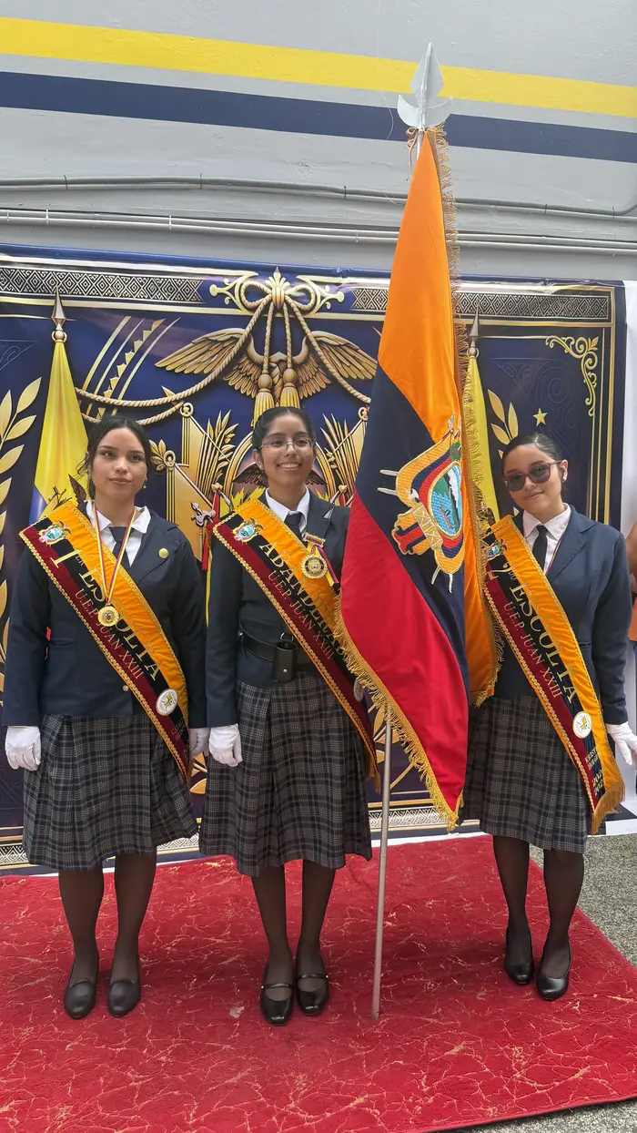 Estudiantes del colegio Juan XXIII con bandas de honor junto a su bandera en la ceremonia de abanderados